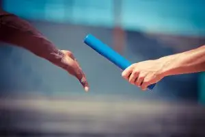 Übergabe Übergabe eines blauen Staffels beim Staffellauf.