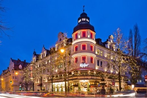 Ansicht des Eingangs vom Hauptgebäude von Käfer Feinkost mit weihnachtlicher Beleuchtung.