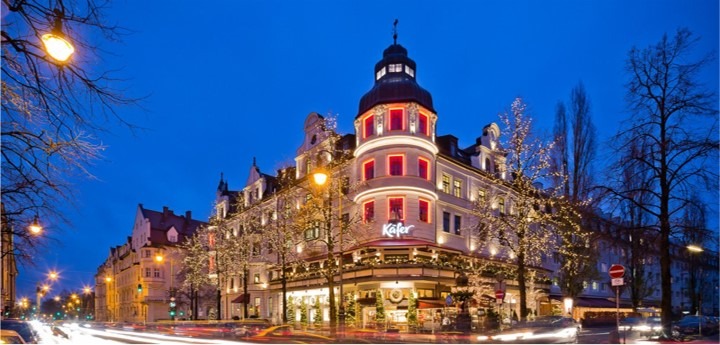Ansicht des Eingangs vom Hauptgebäude von Käfer Feinkost mit weihnachtlicher Beleuchtung.