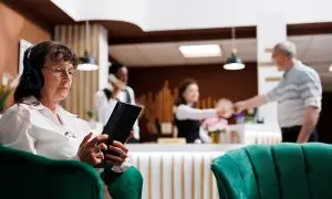 EBC_AdobeStock_659183382 Frau bei Buchung von Extras per Tablet in einer Hotellobby