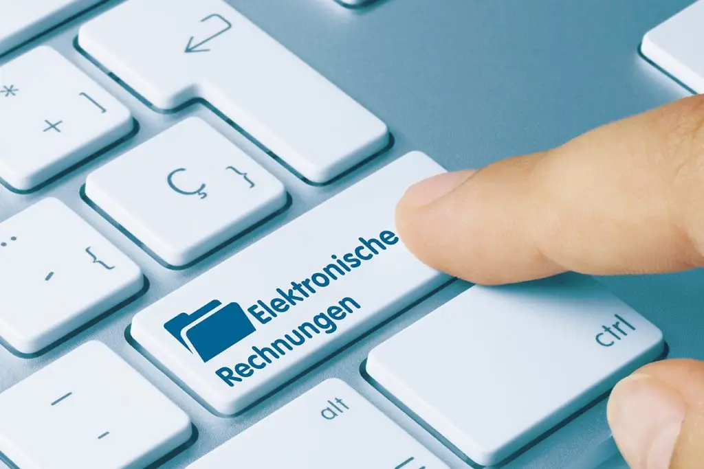 Ausschnitt einer Tastatur, auf die ein Zeigefinder auf die Enter-Taste tippt, welche mit "Elektronische Rechnungen" beschriftet ist.