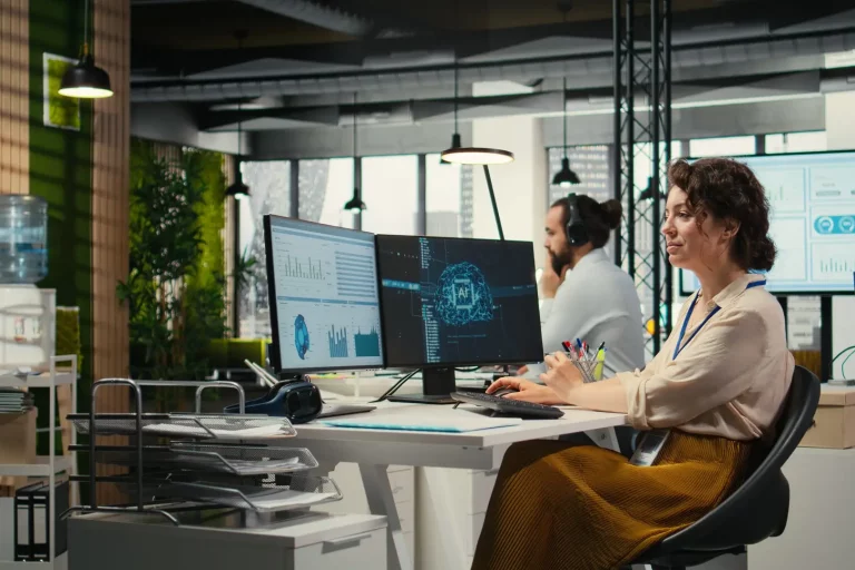Office administrator checking monthly reports with AI analytics platform Büroverwalter, der Monatsberichte mithilfe einer KI-Analyseplattform überprüft und dabei Algorithmen auf Basis neuronaler Netze sowie Automatisierungsmaßnahmen zur Effizienzsteigerung einsetzt. Vertreter eines IT-Unternehmens bei der Arbeit.