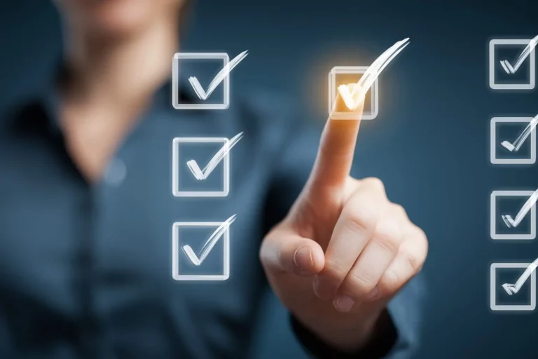 AdobeStock_2113714738 weiße Haken auf einer Glasscheibe. Jemand tippt mit dem Finger auf einen der Haken